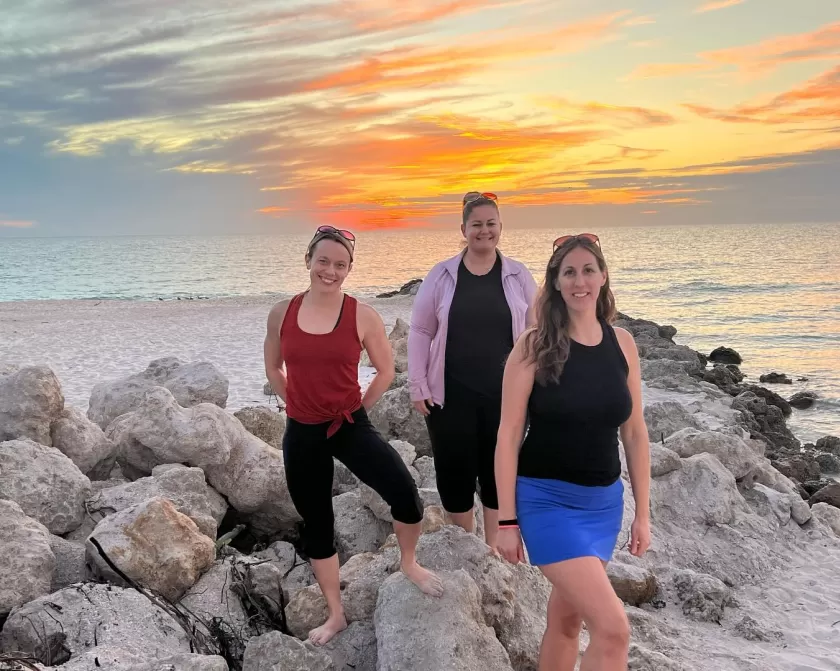 Three women at beach sunset estero